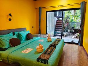 a bedroom with two rubber ducks sitting on a bed at Green Valley Lodge in Khao Sok National Park