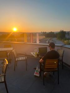 een man die op een stoel voor een laptop zit bij Xerio Motel in Horn