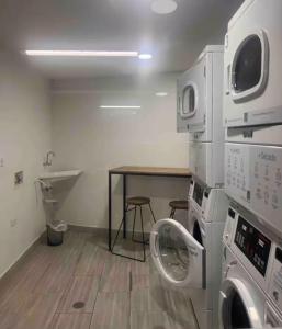 a laundry room with a washing machine and a table at Confortable apartaestudio in Manizales