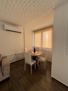 a dining room with a table and chairs and a couch at M apartman in Paraćin +4 photos