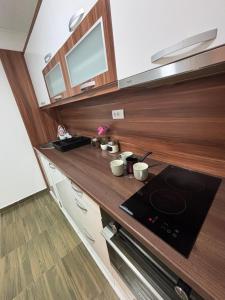 a kitchen with wooden cabinets and a stove top oven at M apartman in Paraćin