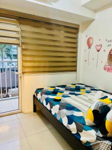 a bedroom with a bed with a large window at Shell Residences Manila by PauL in Manila +13 photos