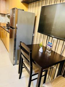 a kitchen with a black table and a refrigerator at Shell Residences Manila by PauL in Manila