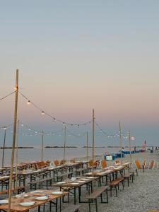 Eine Reihe von Tischen am Strand mit Lichtern in der Unterkunft Hotel Sassonia in Fano