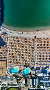 Draufsicht auf ein großes Gebäude mit Strand in der Unterkunft Hotel Sassonia in Fano