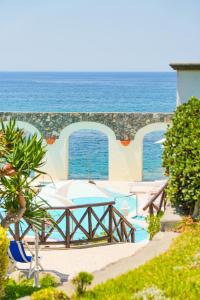 a pool with a table and chairs and the ocean at Hotel Terme Tritone Resort & Spa in Forio d'Ischia