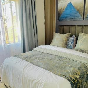 a bedroom with a bed with a painting on the wall at Asanta Guest House in Ladysmith
