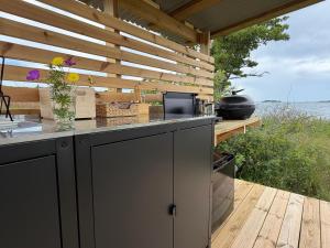 eine Außenküche mit einer hölzernen Pergola in der Unterkunft Seglinge Glamping in Norrön