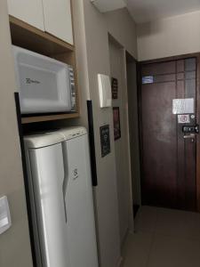 a microwave on top of a refrigerator in a room at Studio miguel II in Rio de Janeiro