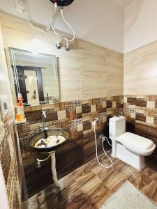 a bathroom with a sink and a toilet at Sai Srushti Homes in Gonikoppal
