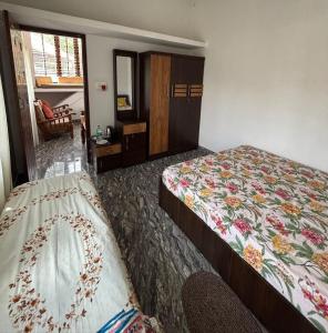 a hotel room with two beds and a window at Sai Srushti Homes in Gonikoppal
