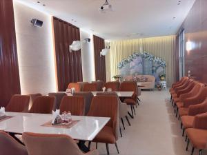 a restaurant with tables and chairs in a room at Radiance Hotel in Sirsa