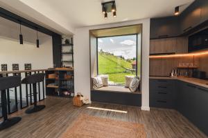 a kitchen with a large window with a view at Serra Chalet in Fundata +53 photos