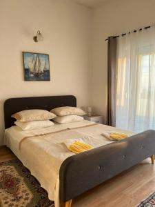 a large bed in a bedroom with a large window at Suka Apartments in Ulcinj