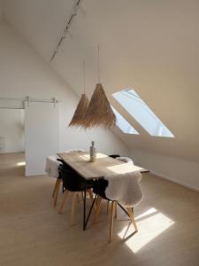 a dining table and chairs in a room with a window at Le Grenier in Trois-Ponts