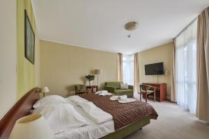 a hotel room with a bed and a living room at Willa Wodnik in Świnoujście