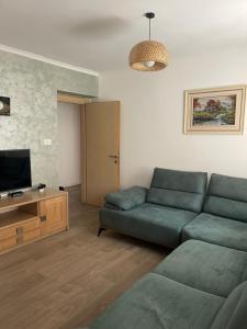 a living room with a couch and a flat screen tv at Mateo Apartment in Himare