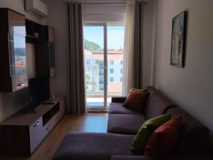 a living room with a couch and a large window at Apartman Vesna in Budva