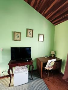 a room with a desk and a tv and a chair at Cariari Bed & Breakfast in San José