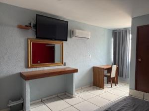 a hotel room with a mirror and a tv on the wall at Hotel Jar8 Boca -Cerca WTC y plazas comerciales- in Veracruz