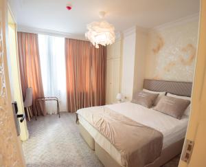 a bedroom with a large bed and a chandelier at Gala Terrace Hotel & Restaurant in Baku +20 photos