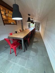a long wooden table and red chairs in a room at Rodzinne Zacisze in Radawa