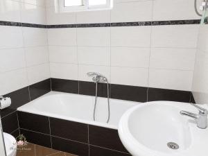 a bathroom with a bath tub and a sink at Flowers House in Gjirokastër