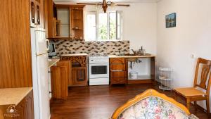 a kitchen with wooden cabinets and a white stove top oven at Flowers House in Gjirokastër