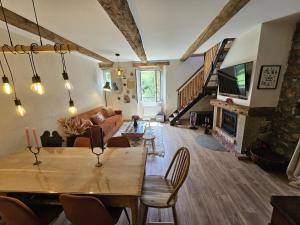 a living room with a table and a fireplace at La Parenthèse Enchantée Chalet in Beuil