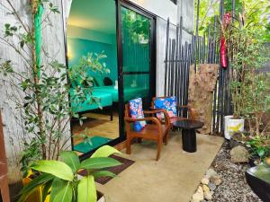 a room with a chair and a table and some plants at Green Valley Lodge in Khao Sok National Park