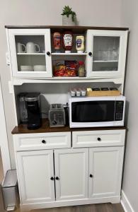 a kitchen with white cabinets and a microwave at Guest Suite in Langford in Goldstream Station