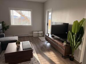 a living room with a couch and a television at Guest Suite in Langford in Goldstream Station +13 photos