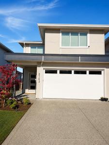 a large house with a white garage door at Guest Suite in Langford in Goldstream Station