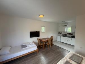 a living room with a bed and a table and a kitchen at B-I Apartmani in Glavatske Kućice