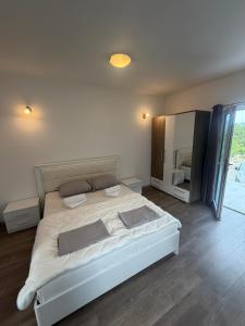 a bedroom with a large bed and a large mirror at B-I Apartmani in Glavatske Kućice