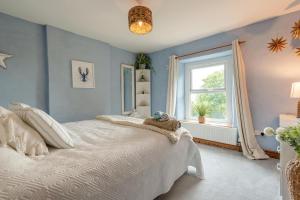 a bedroom with a white bed and a window at 3 Bed in Lydbrook oc-94490 in Lydbrook