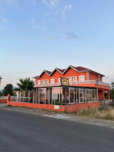 a red building on the side of a street at Zefigrillhouse in Tale