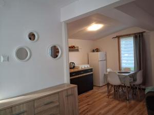 a kitchen and dining room with a table and a refrigerator at Oleandria -,,Domek Jeżynka" nr 30 in Biskupiec
