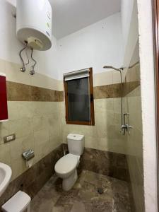 a bathroom with a toilet and a sink at Zefigrillhouse in Tale