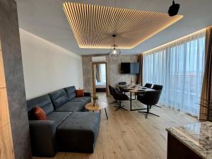 a living room with a blue couch and a table at Хотел Камъните in Burgas