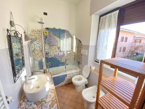 a bathroom with a sink and a toilet and a window at La DISCOGRAFICA, Spaziosa per Gruppi e Famiglie, vicina al Parco Acquatico Leolandia in Trezzano Rosa