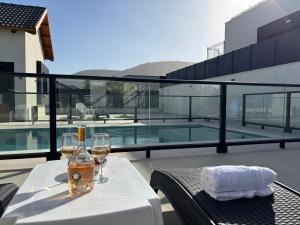 a table with wine glasses and a bottle on a balcony at Leo Ari Suites- סוויטות לאו ארי in Sifsufa