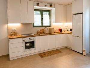 a kitchen with white cabinets and a sink and a refrigerator at Our Kea apartment in Otziás