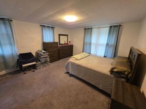 a bedroom with a bed and a dresser and windows at A J House in Plano