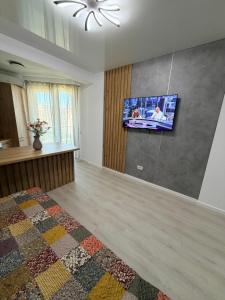 a bedroom with a tv on the wall and a bed at La Ion Residence 1 in Năvodari