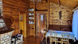 a dining room with a table and chairs in a cabin at Domek Szumin-Wywłoka in Majdan
