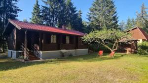 a log cabin with a yard and a house at Domek Szumin-Wywłoka in Majdan