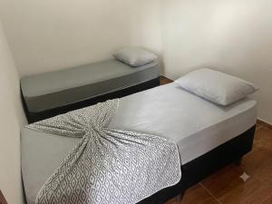 two twin beds in a room withthritisthritisthritisthritisthritisthritisthritisthritisthritis at POUSADA Br381 in Extrema