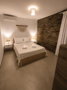 a bedroom with a bed and a brick wall at Our Kea apartment in Otziás