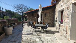 a patio with a table and chairs and an umbrella at Casa Alcántara in Vilamelle